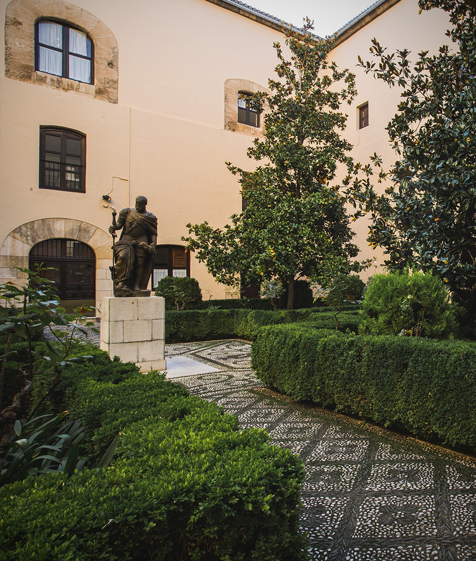 Imagen de uno de los patios del Hospital Real donde en el centro se encuentra una estatua