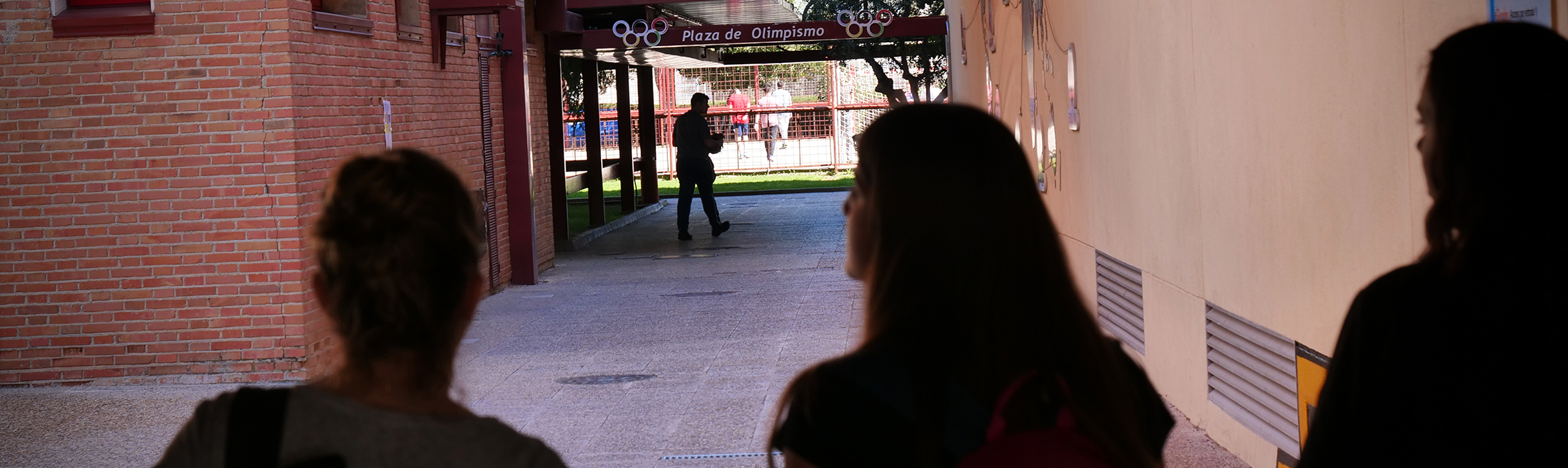 Estudiantes de la Facultad de CIencias del Deporte caminando por los espacios exteriores situados a la sombra