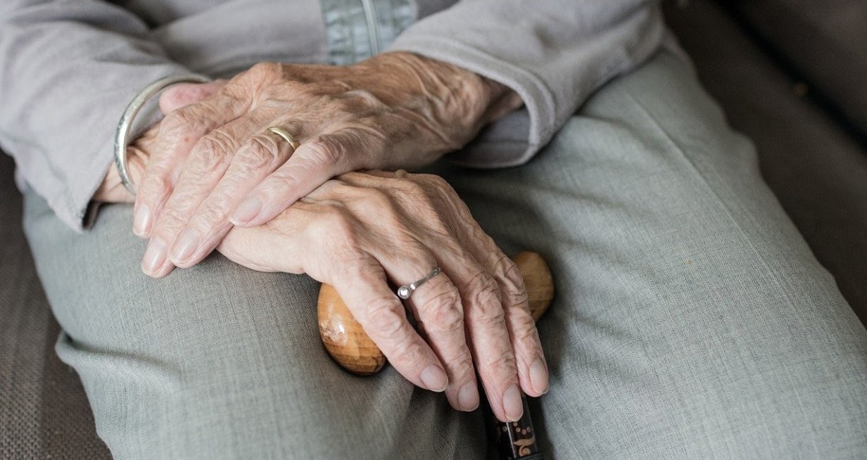 La imagen muestra las manos cruzadas de una persona de avanzada edad